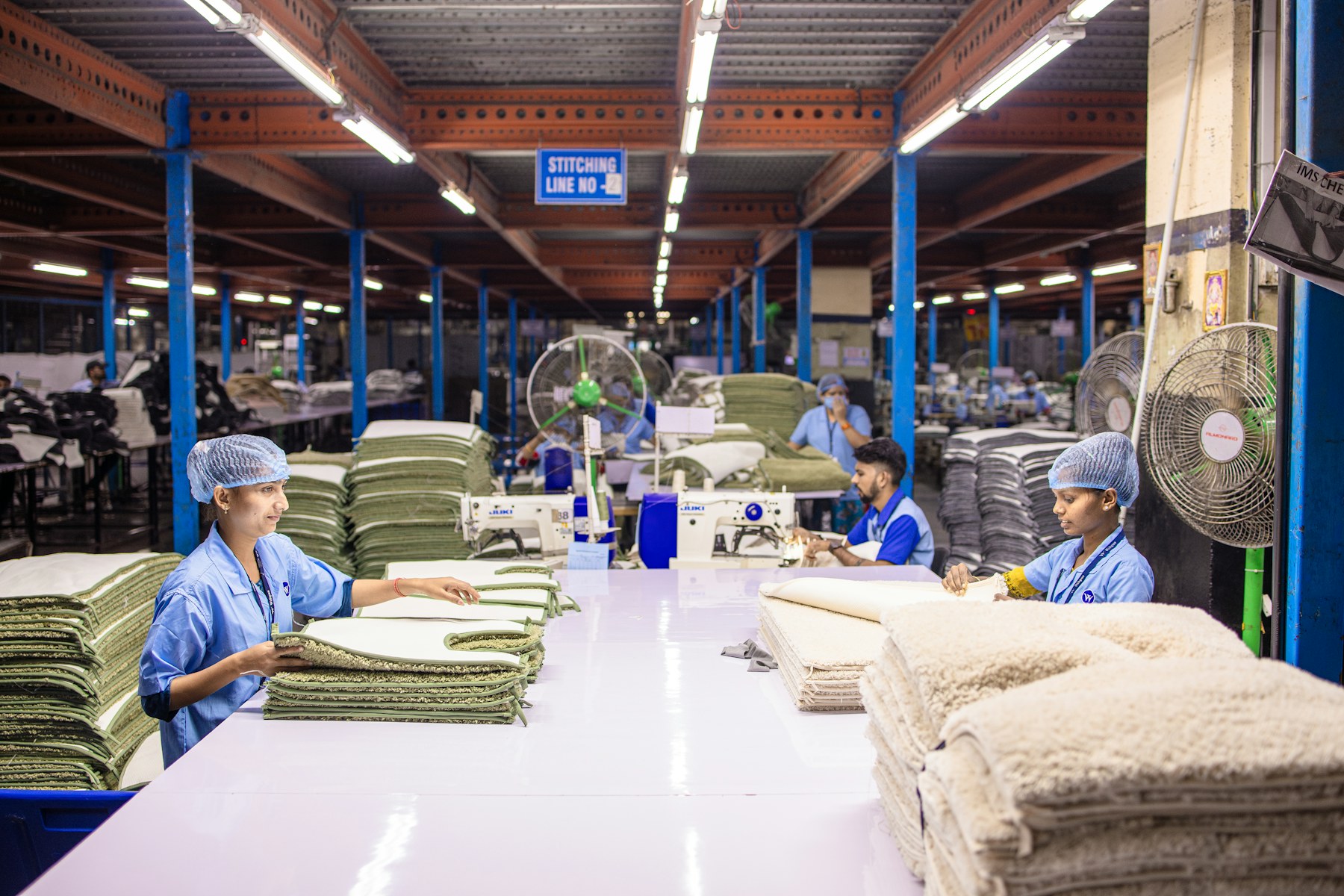 Colleagues preparing textiles in a factory; illustrative stock photography