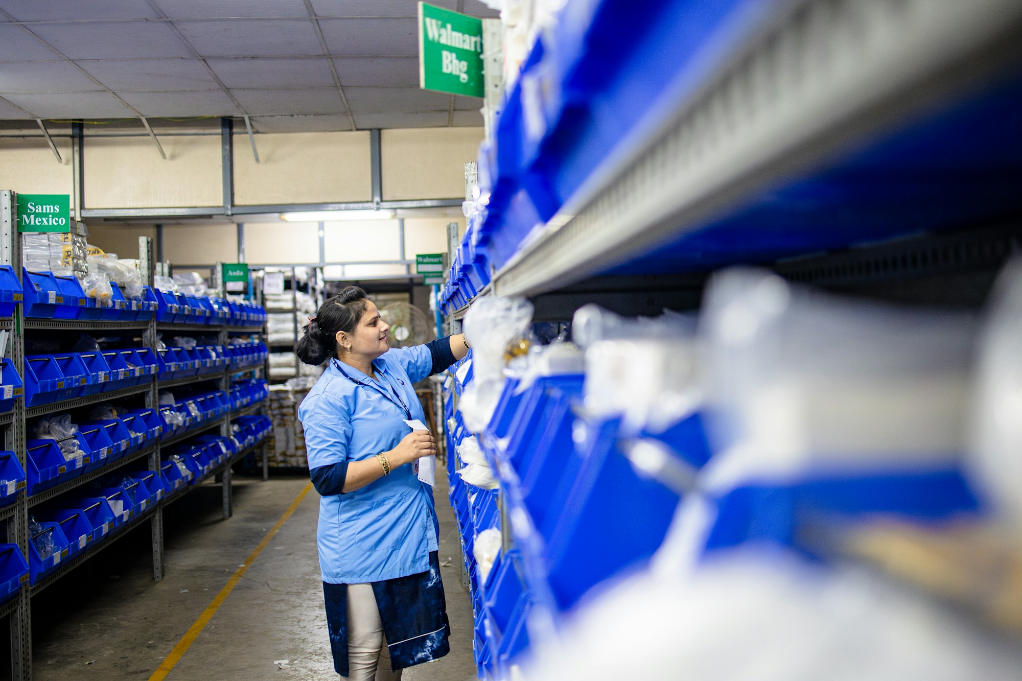 Worker organising warehouse components; illustrative stock photography
